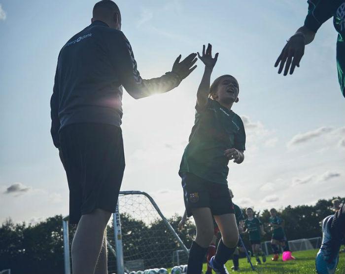 Fodbolddreng giver high-five til træner